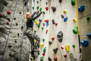girl at indoor climbing wall at Elevation Place in Canmore