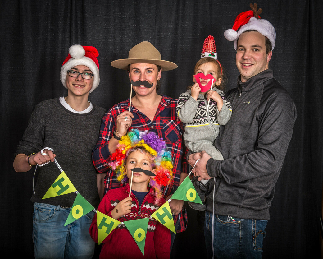 Family of three holding fun Christmas decorations